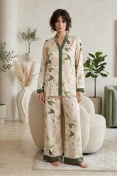 Woman wearing a floral pajama set in a cozy living room.