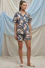 Woman wearing a patterned outfit against a draped fabric background