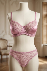 Pink lace lingerie set on a mannequin against a decorative room background