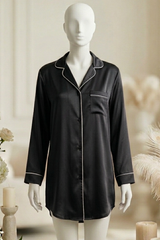 Black satin pajama top on a mannequin with decorative flowers and candles in the background