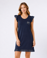 Woman wearing a navy blue nightdress with lace details on a white background