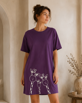 Woman wearing a purple dress with animal prints in a home setting