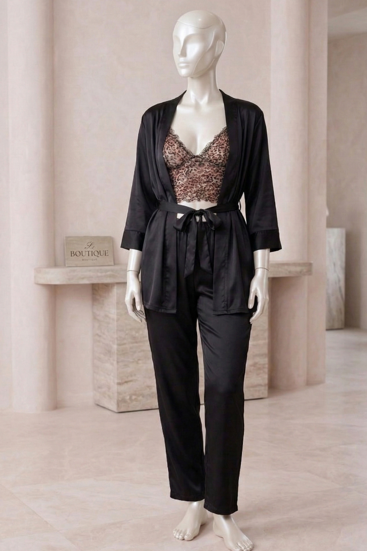 Mannequin wearing a black outfit with a patterned top in a neutral setting