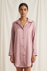 Woman wearing a pink satin nightshirt against a white background