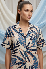 Woman wearing a patterned shirt with a soft draped fabric background