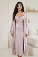 Woman wearing a light purple dress with lace detailing in a bright room.
