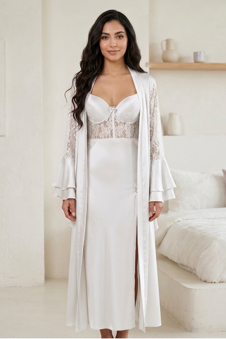 Woman wearing a white lace nightgown with a matching robe in a bright room.