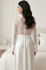 Woman wearing a lace wedding dress in a bedroom setting