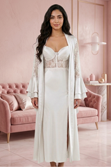 Woman in a white lace dress with a matching long jacket in a pink room.