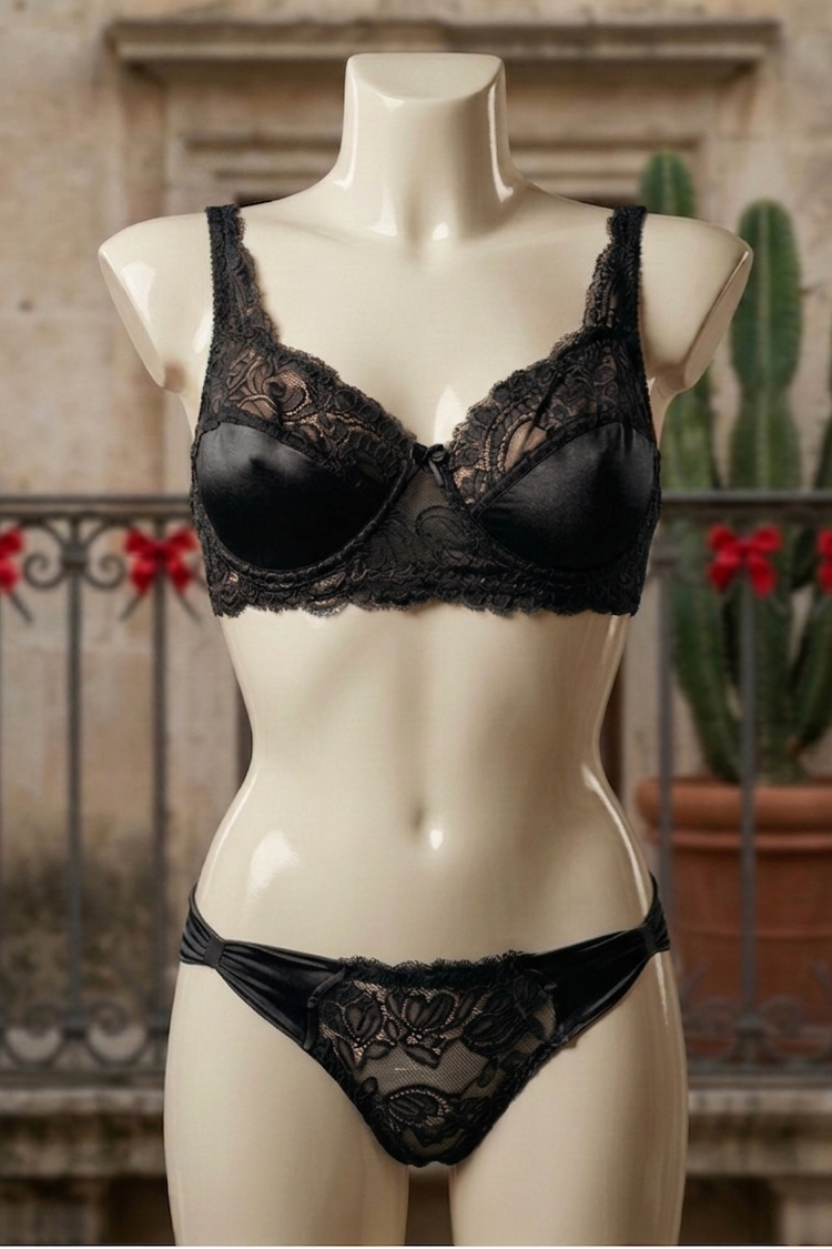 Black lace lingerie set on a mannequin against an outdoor background with plants.
