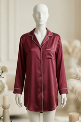 Maroon satin nightshirt on a mannequin with decorative flowers and candles in the background