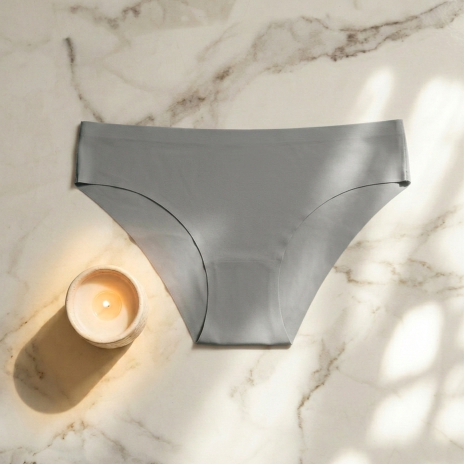 Gray underwear on a marble surface with a candle