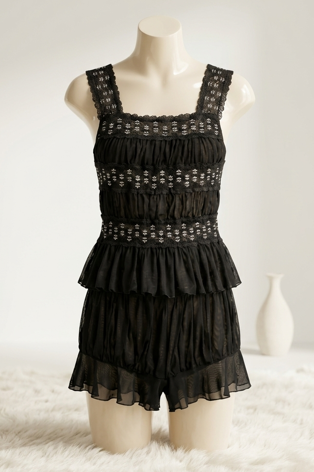 Black lace dress on a mannequin against a white background