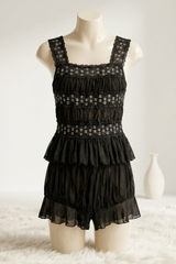 Black lace dress on a mannequin against a white background